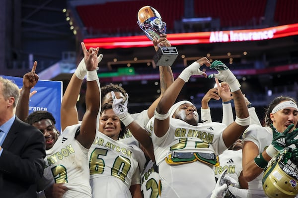 Grayson players celebrate with the trophy after their state championship game win over Carrollton.