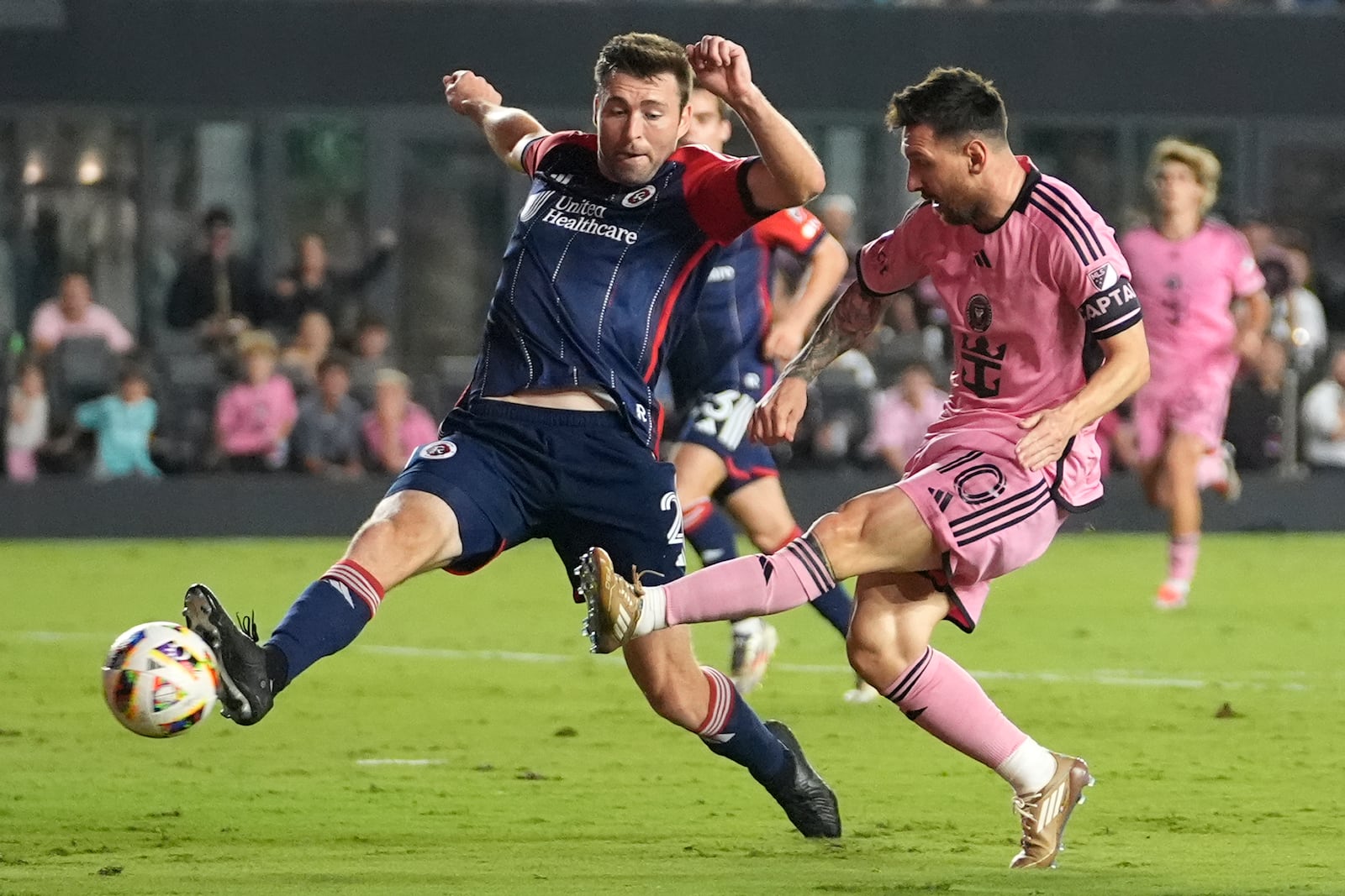 Inter Miami forward Lionel Messi (10) scores a goal as New England Revolution defender Dave Romney, left, defends during the second half of an MLS soccer match, Saturday, Oct. 19, 2024, in Fort Lauderdale, Fla. (AP Photo/Lynne Sladky)