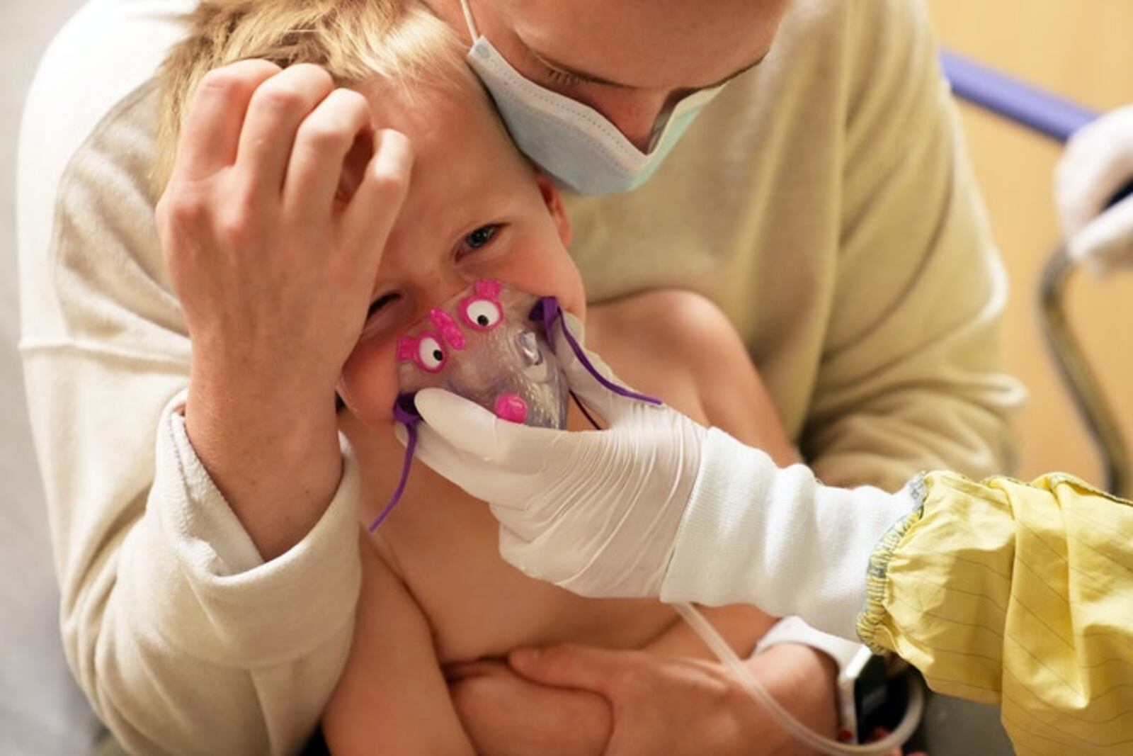 In this file photo, Meredith Legree of Lakeville, Minnesota, holds her frightened son Andrew, 3, as respiratory therapist Sirena Ortega holds a mask to his face for a nebulizer treatment to help decrease inflammation in his airway and allow him to breathe easier as they waited for the results of his RSV test at Children’s Hospital of St. Paul. (Minneapolis Star Tribune/TNS)