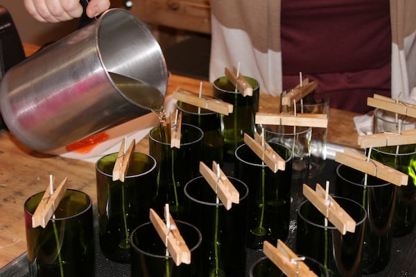 Erica Brown, who owns Corked Candles with her mom, pours wax into recycled wine bottles. Courtney Kueppers/AJC