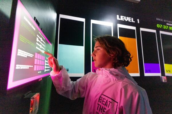 A boy plays a game at Beat the Bomb in Atlanta on Saturday, October 15, 2022. The Brooklyn-based immersive escape room experience recently opened its Atlanta location. (Photo by Jenn Finch)