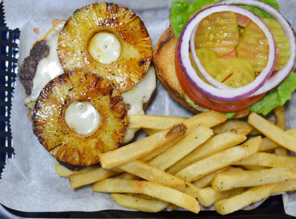 The grilled pineapple is nicely caramelized atop the Big Joint Burger at Sliders Burger Joint. CONTRIBUTED BY HENRI HOLLIS