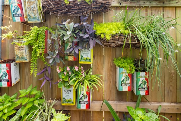 Olive oil tins provide attractive (and upcycled) containers for a variety of plants on this fence in New Orleans, a witty way of adding color and a unique design element to this garden.
(Courtesy of Derek Trimble)