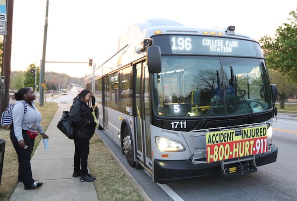 Jamila Hazel (left) and Patricia Thompson wait to get on the 196 route in Riverdale, Ga. on  March 29, 2019. This stop currently has no bus shelter or bench for riders as they wait. Clayton County is adding bus shelters and benches to stops after years of promising to do so. EMILY HANEY/AJC FILE 2019 