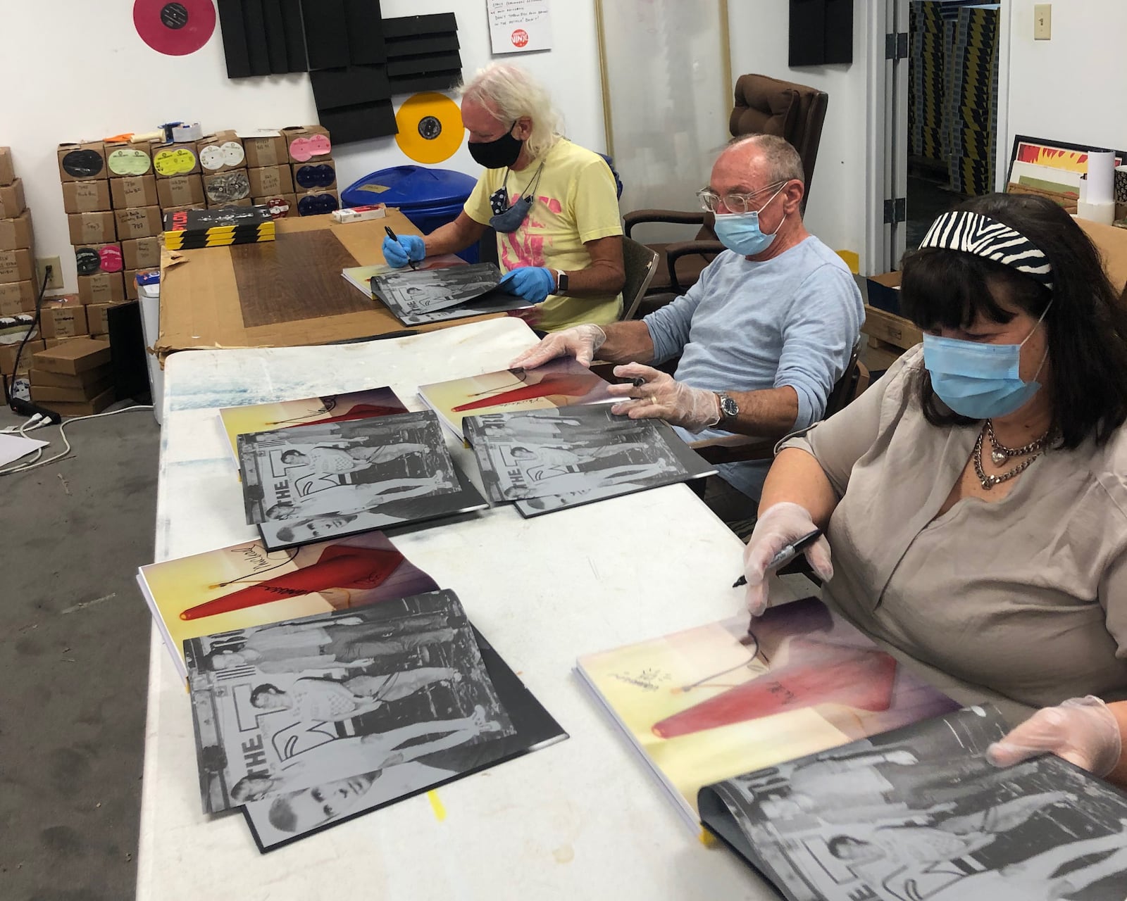 The surviving members of Pylon (from left), Michael Lachowski, Curtis Crowe and Vanessa Briscoe Hay sign the first run of the new "Pylon Box," which documents much of the band's recording career. Courtesy of Caroline Barfield