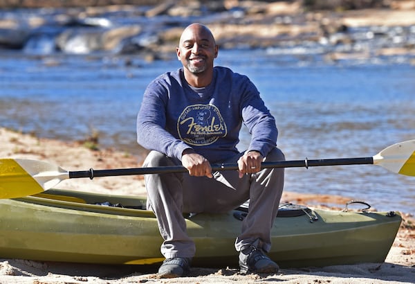 Eric Grant with his kayak on the banks of the South River near his home in Stockbridge in December. (Hyosub Shin / Hyosub.Shin@ajc.com)