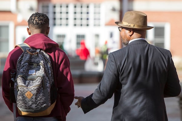 Dr. Illya Davis, right, 52, speaks with a student on the way to teach an honors class of Intro to African-American Studies at Morehouse College in Atlanta on Wednesday, Nov. 15, 2017. (CASEY SYKES / CASEY.SYKES@AJC.COM)