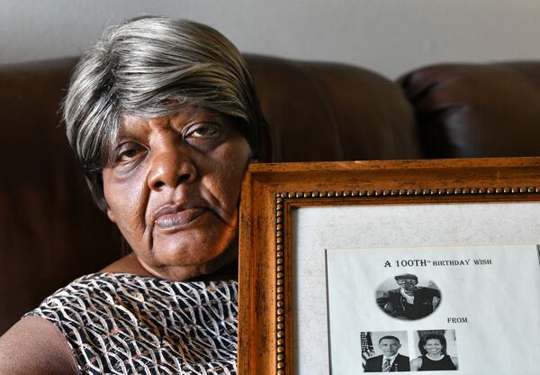 Ruby Jackson holds a framed "100th Birthday Wish" message from Barack and Michelle Obama for her father Charles Coleman, who died of COVID-19 at the age of 106. Coleman, born on July 4, 1914, was a longtime farmer. (Hyosub Shin / Hyosub.Shin@ajc.com)