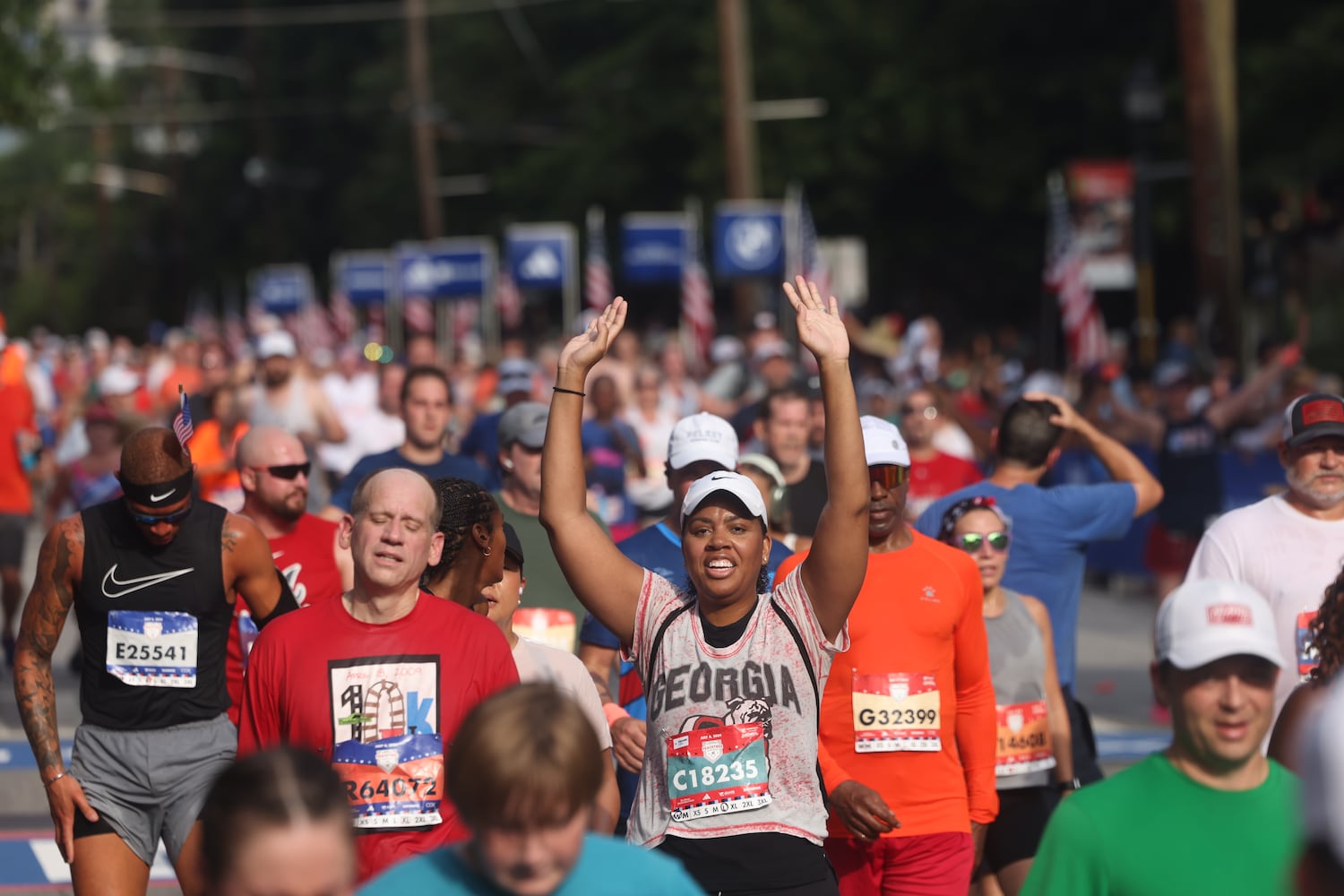 Runners celebrate at the finish of the 55th running of the Atlanta Journal-Constitution Peachtree Road Race in Atlanta on Thursday, July 4, 2024.   (Jason Getz / AJC)