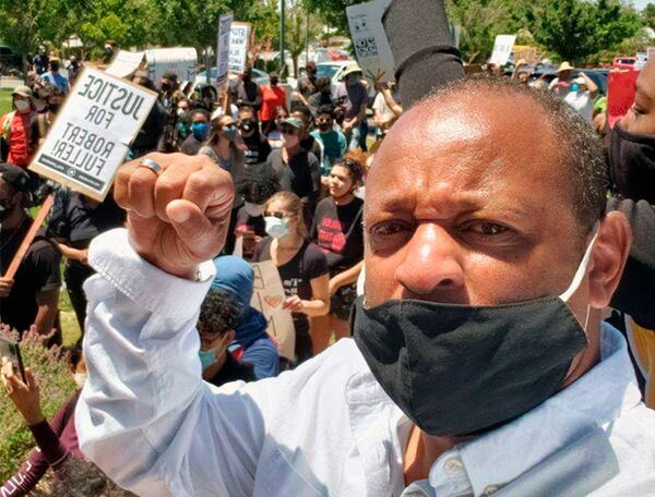 This photo provided by activist Najee Ali shows  Ali at a rally in the park where the body of Robert Fuller was found.