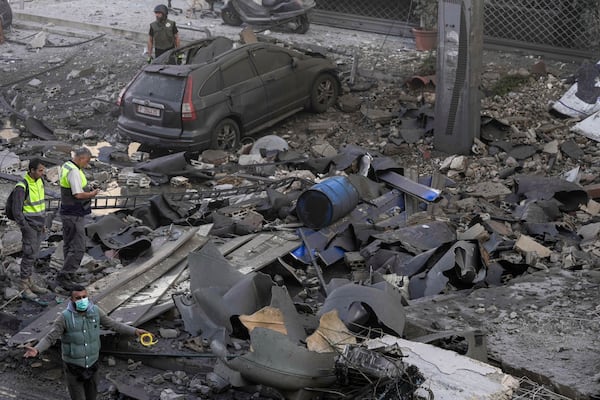 Rescuers check a building hit by an Israeli airstrike in Chiyah, the southern suburb of Beirut, Lebanon, Friday, Nov. 22, 2024. (AP Photo/Bilal Hussein)