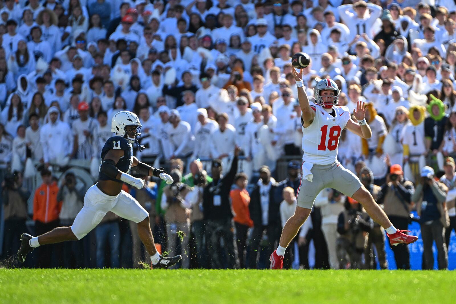 Ohio State quarterback Will Howard (18) throws a pass while being pressured by Penn State defensive end Abdul Carter (11) during the second quarter of an NCAA college football game, Saturday, Nov. 2, 2024, in State College, Pa. (AP Photo/Barry Reeger)