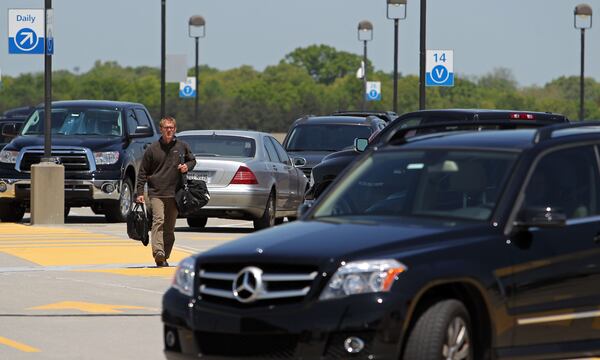 April 23, 2013 - Atlanta, Ga: A traveler walks toward the north terminal from the parking deck at Hartsfield-Jackson Atlanta International Airport Tuesday morning in Atlanta, Ga., April 23, 2013. Nearly a year after the Atlanta airport opened its new international terminal, it is already planning for the next expansion. Hartsfield-Jackson International Airport's master plan study shows the airport will soon need more parking, and will also need more people-mover train capacity inside the terminal, more security screening line space, more gates and more airfield capacity - such as another runway -- in the next 20 years JASON GETZ / JGETZ@AJC.COM