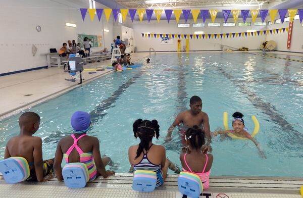 June 13, 2014 Decatur - Jamia Burton (right), 5, swims as instructor Jhari Rickettes helps in the indoor swimming pool at South DeKalb Family YMCA in Decatur on Friday, June 13, 2014. Nearly $5 million in taxpayer money would be used to renovate a members-only YMCA, according to a proposal pending before the DeKalb County Commission. Residents opposed to the deal say it amounts to a handout for a private business, but supporters say it would bring more services to south DeKalb. HYOSUB SHIN / HSHIN@AJC.COM