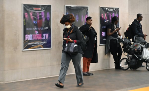 A MARTA commuter wearing a mask makes her way during afternoon rush hour at the Five Points MARTA station on Thursday, March 12, 2020. (Hyosub Shin / Hyosub.Shin@ajc.com)