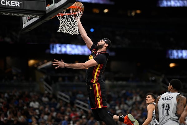 Atlanta Hawks forward Larry Nance Jr., left, goes up to shoot as Orlando Magic forward Tristan da Silva, second from right, and guard Gary Harris (14) watch during the first half of an NBA basketball game, Monday, Feb. 10, 2025, in Orlando, Fla. (AP Photo/Phelan M. Ebenhack)