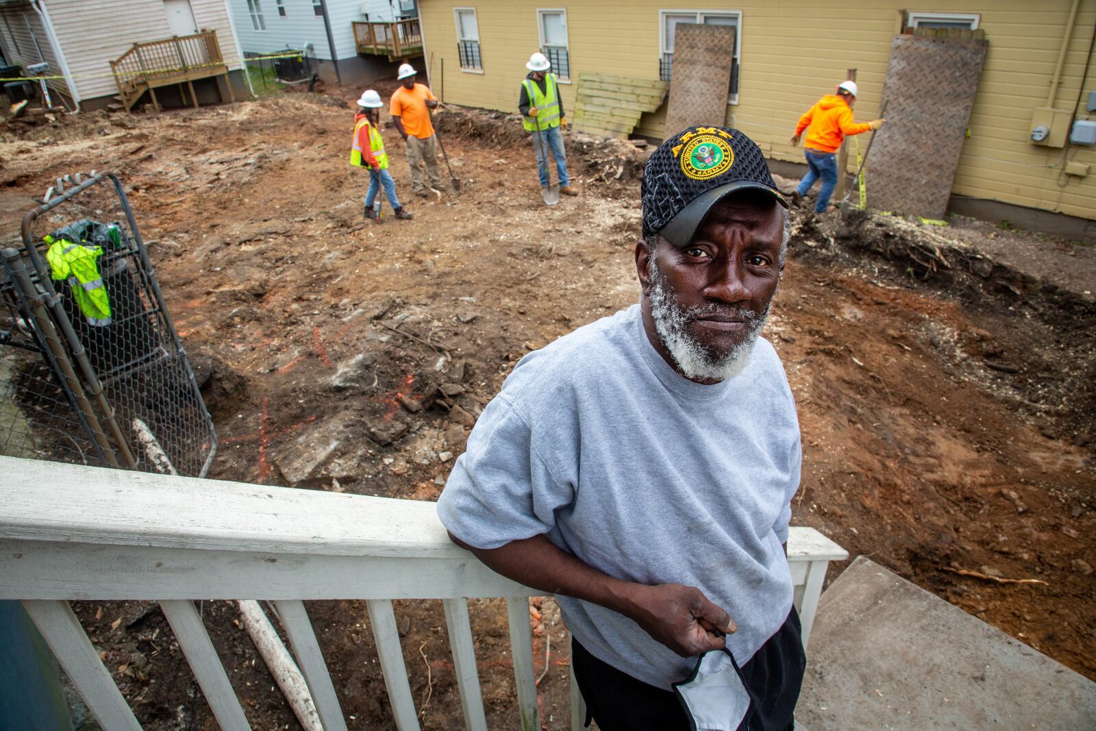 Ellis Smith stands on his porch as workers remove dirt from a Westside lead Superfund site Wednesday, February 2, 2022. STEVE SCHAEFER FOR THE ATLANTA JOURNAL-CONSTITUTION