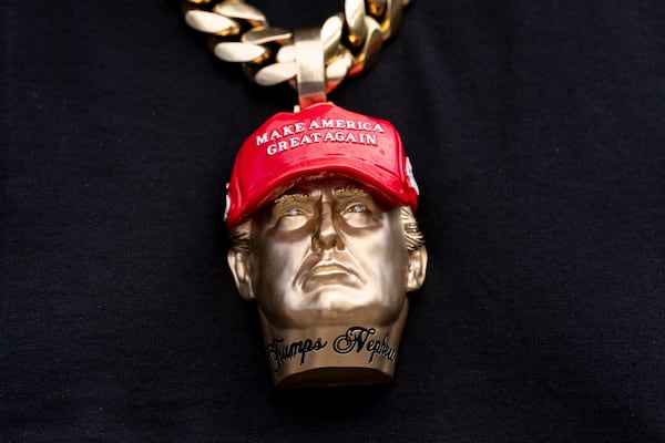 Forgiato Blow wears a necklace with a likeness of former President Donald Trump before Republican presidential nominee former President Donald Trump speaks at a campaign event at the Cobb Energy Performing Arts Centre, Tuesday, Oct. 15, 2024, in Atlanta. (AP Photo/Alex Brandon)