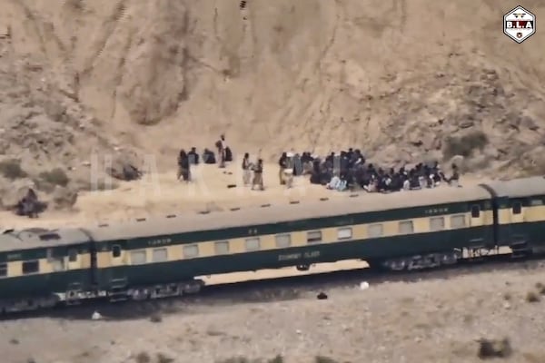 In this frame grab from a video released by the Baluchistan Liberation Army shows people outside the a train after being attacked by the BLA on its transit from Quetta to the northern city of Peshawar, in Bolan district, Pakistan's southwestern Balochistan province, March 12, 2025..(BLA via AP)