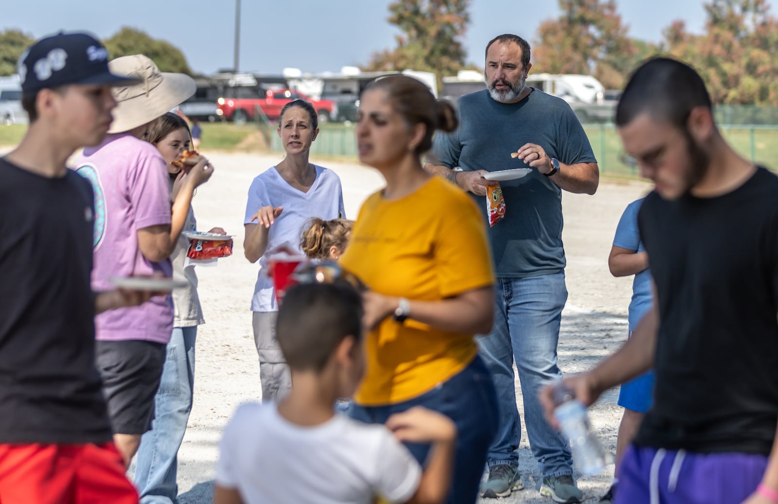 (Left to right center background) - Shal and C.J. Gagne from Naples, Florida, enjoy free pizza for the evacuees. RVs were parked at the Atlanta Motor Speedway Wednesday, Oct. 9, 2024 with evacuees fleeing Hurricane Milton. Several Georgia hotels and campgrounds are opening their doors to evacuees. (John Spink/AJC)