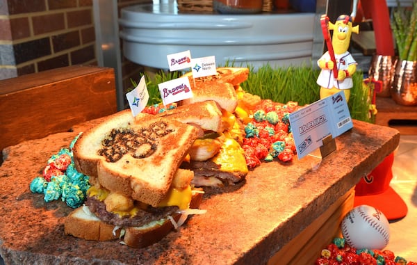 BLOOPER Burger (Section 113). Braves Mascot BLOOPER kept busy this offseason in the ballpark kitchen, designing his favorite new snack at SunTrust Park. This giant sandwich features a bit of everything, including 4 cheeseburger patties, a footlong hot dog, and chicken tenders, all with lettuce, tomato, onion, and jalapenos, covered in cheese sauce and nestled inside cross cut Texas toast. Served with Braves Country candied popcorn. $26.00