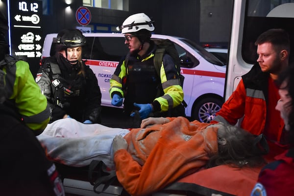 Paramedics carry a body of a civilian killed after a Russian missile hit a private medical clinic in Zaporizhzhia, Ukraine, Tuesday, Dec. 10, 2024. (AP Photo/Andriy Andriyenko)