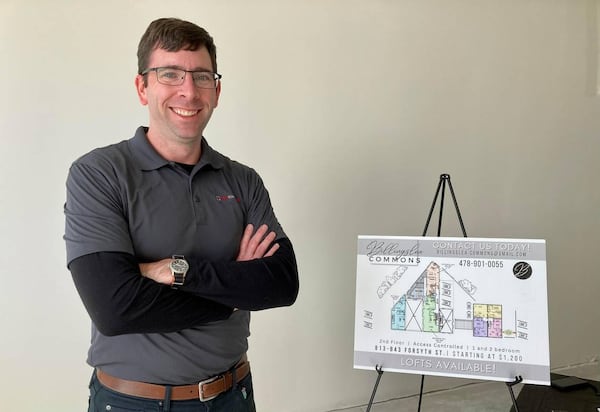 FILE: NewTown Macon’s executive director and CEO Josh Rogers stands next to a rendering showing commercial space at the new Billingslea Commons. (Photo Courtesy of Becky Purser)