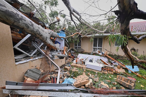 A fallen tree lies on a damaged house in Gold Coast, Australia, Friday, March 7, 2025. (Dave Hunt/AAP Image via AP)