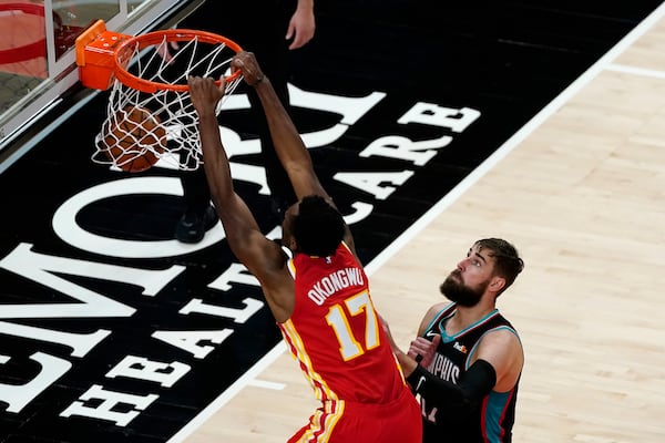 Atlanta Hawks forward Onyeka Okongwu (17) scores as Memphis Grizzlies center Jonas Valanciunas (17) defends in the second half of an NBA basketball game Wednesday, April 7, 2021, in Atlanta. (AP Photo/John Bazemore)