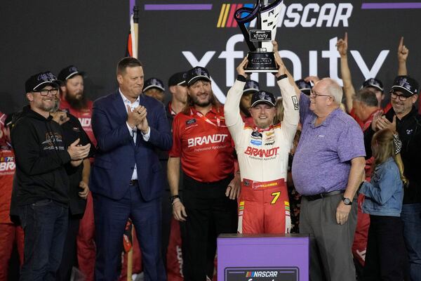 Justin Allgaier holds up the trophy as Team owner Dale Earnhardt Jr., left, cheers after winning the championship after a NASCAR Xfinity Series auto race, Saturday, Nov. 9, 2024, in Avondale, Ariz. (AP Photo/John Locher)