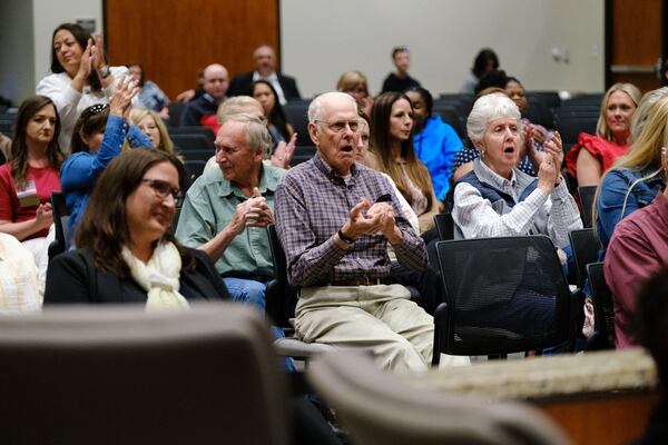 Audience members at a Cherokee County school board meeting cheer for a speaker who advocates for removing books some deem objectionable. Members of the public voiced their opinions at the school board meeting in Canton on Thursday, April 21, 2022.   (Arvin Temkar / arvin.temkar@ajc.com)