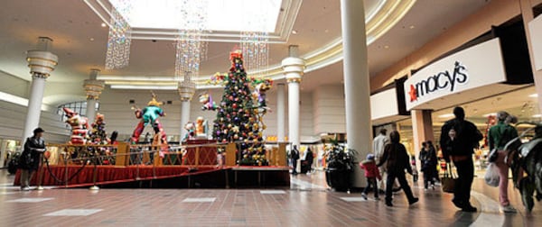 Visitors stroll past the Santa stage into Macy's. (Bita Honarvar / AJC file photo0