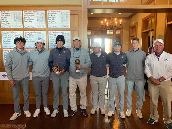 Prince Avenue coach Jimmy Phillips holds the runner-up trophy and Will Baker holds the medalist's trophy following the Wolverine Classic at the Curahee Golf Club.