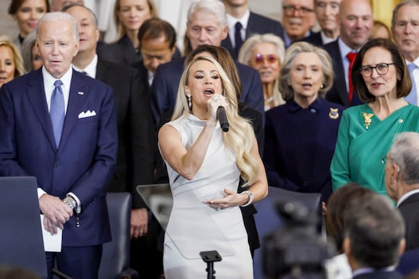 Former President Joe Biden (left) looks on as country singer Carrie Underwood (center) performs during the inauguration ceremony in Washington on Monday. Before his term, expired Biden moved to ban new offshore drilling in most U.S. coastal waters.