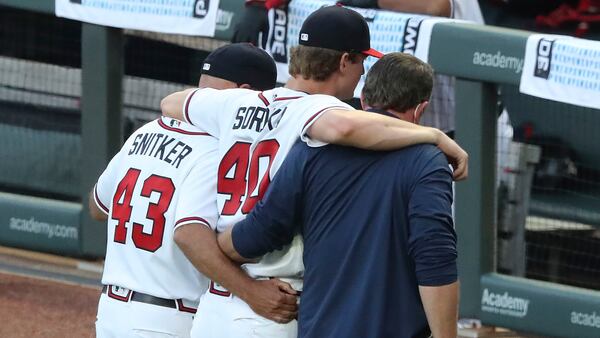 Braves manager Brian Snitker and a trainer help pitcher Mike Soroka off the field in 2020. (Curtis Compton/AJC)