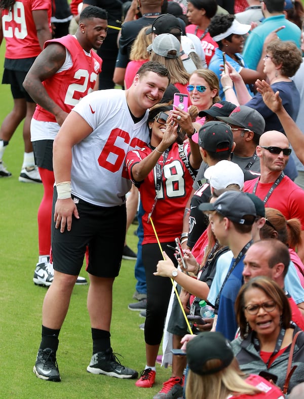 The rook, Chris Lindstrom, makes some new friends at the close of an offseason training session. (Curtis Compton/ccompton@ajc.com)