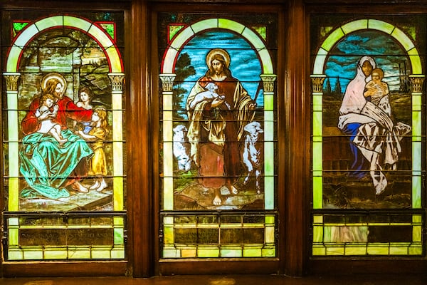 The triptych on display inside of First Congregational Church is comprised of individual panes dedicated to families connected to the church's history. The stained glass windows were first installed in 1909. (Ronald Williams/AJC)