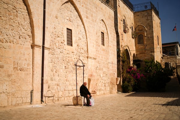 An Armenian resident sits at the main square of the Armenian quarter in Jerusalem, Thursday, Nov. 21, 2024. (AP Photo/Francisco Seco)