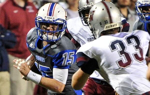 Walton's Jack Hoskyn (15) makes a gain on an interception as Woodstock's Louis Hall (33) defends during a high school football game, Friday, Oct. 16, 2015, in Marietta. (John Amis/Special to AJC)