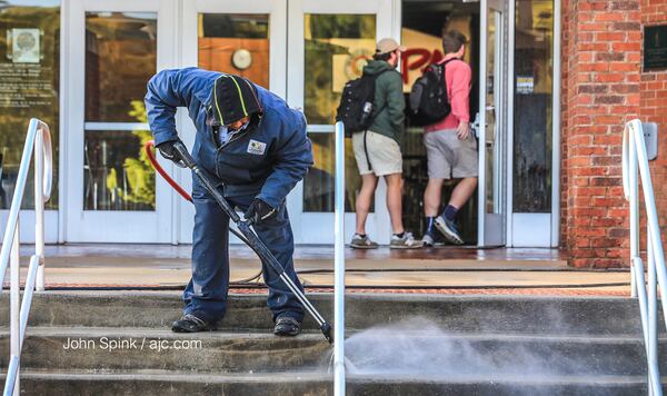 Gordon Gray with Georgia Tech's landscaping service layered up for Thursday morning’s chill as he pressure-washed outside the student center. JOHN SPINK / JSPINK@AJC.COM