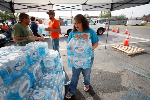 Chasity Bridges from Chattooga County carries a case of water alongside other volunteers outside Summerville City Hall. The city is providing water to affected residents; the water is still not fully restored in Chattooga county after the floods caused by the severe rains on Labor Day weekend.
Sunday, September 7, 2022. Miguel Martinez / miguel.martinezjimenez@ajc.com