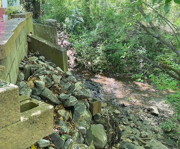 Willow Brook resident, Tony Dunbar, said he built a 12-foot retaining wall on the creek four years ago, and says he’s now building a driveway on the side of his home, located near the front of the subdivision, so residents in the back have a way out during a severe flood. Credit: Adrianne Murchison