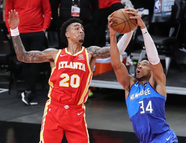 Milwaukee Bucks forward Giannis Antetokounmpo intercepts the pass to Hawks forward John Collins and draws the foul during the final two minutes of Game 3 of the Eastern Conference finals Sunday, June 27, 2021, at State Farm Arena in Atlanta. The Bucks won 113-102 to claim a 2-1 series lead. (Curtis Compton / Curtis.Compton@ajc.com)