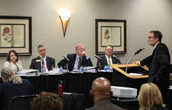 Lawyer Bryan Sells speaks to a witness as members of the State Election Board listen during a hearing held by the State Election Board earlier this year. The board made decisions on 98 cases this past week. (Photo/Austin Steele for The Atlanta Journal-Constitution) 