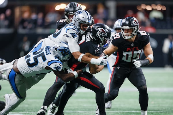 Atlanta Falcons running back Bijan Robinson (7) breaks a tackle against Carolina Panthers defenders during the first half of an NFL football game against the Caroline Panthers Sunday, January 5, 2025, at Mercedes-Benz Stadium in Atlanta. 
(Miguel Martinez/ AJC)