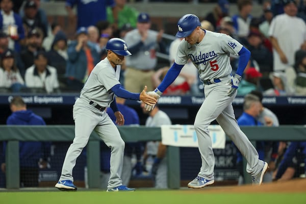 Los Angeles Dodgers’ Freddie Freeman, right, celebrates his three-run home run with third base coach Dino Ebel during the fifth inning. (Jason Getz / Jason.Getz@ajc.com)