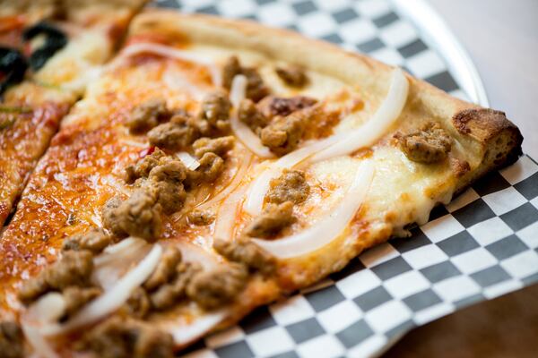 Pizza slice with sausage and onion toppings. Photo credit- Mia Yakel.