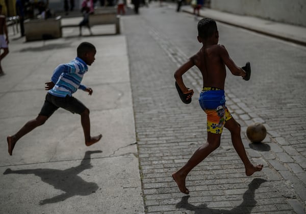 Children kick a ball around during a power outage in Havana, Cuba, Wednesday, Dec. 4, 2024. (AP Photo/Ramon Espinosa)