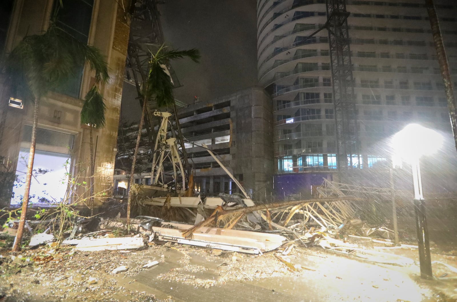 Debris covers the ground near a crane that fell onto a building in St. Petersburg, Fla., as Hurricane Milton's strong winds tore through the area.