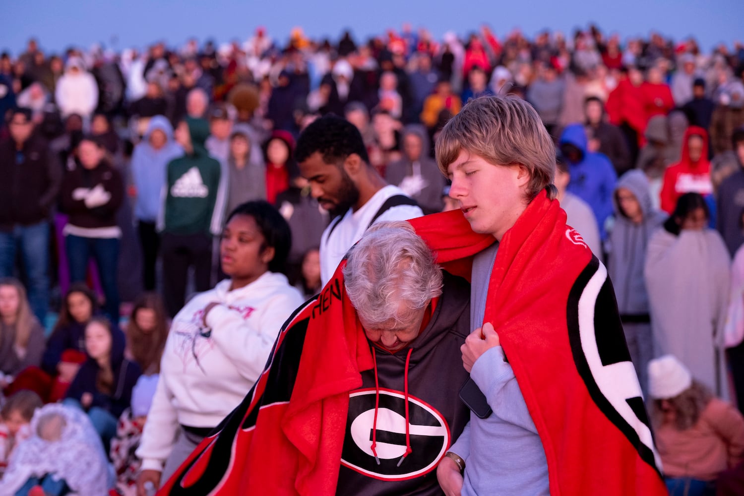 Janet Pannell and her nephew Wesley Pannell pray while huddled together for warmth during Easter sunrise service on top of Stone Mountain on Sunday, March 31, 2024.   (Ben Gray / Ben@BenGray.com)